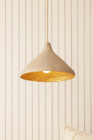 Close up of stone coloured sustainable pendant light with gold interior 
