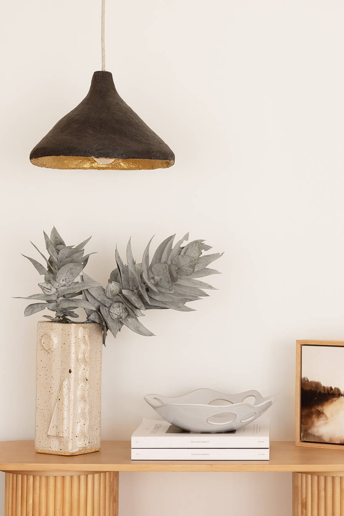 Charcoal sustainable pendant light hanging above a hallway console