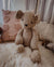 An outstretched hand holds a latte coloured handmade teddy bear soft toy