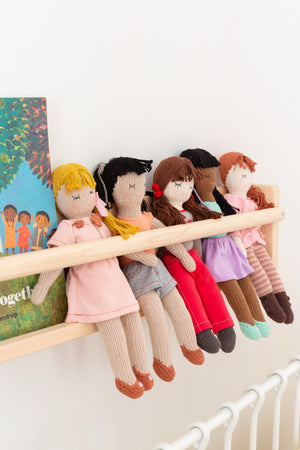  Five handmade and hand knitted woollen dolls sit on a wooden shelf 